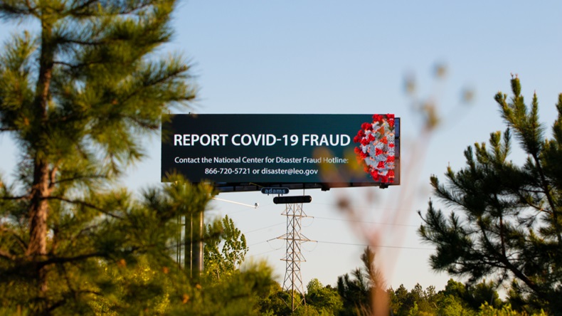"Charlotte, NC / USA - April 9 2020: Billboard promoting a COVID-19 Fraud hotline for those who may be victims of fraudulent activity during the Corona Virus pandemic" 