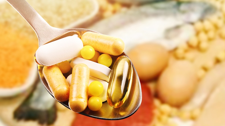 dietary supplements in spoon on protein food background 