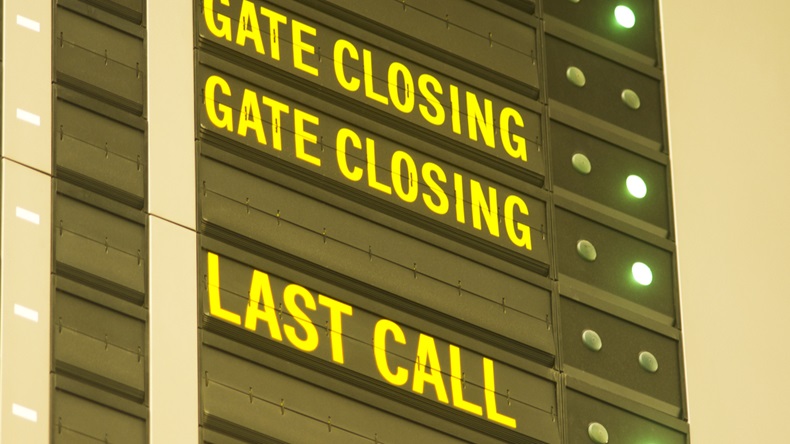 gate closing and last call message on airport information board.
