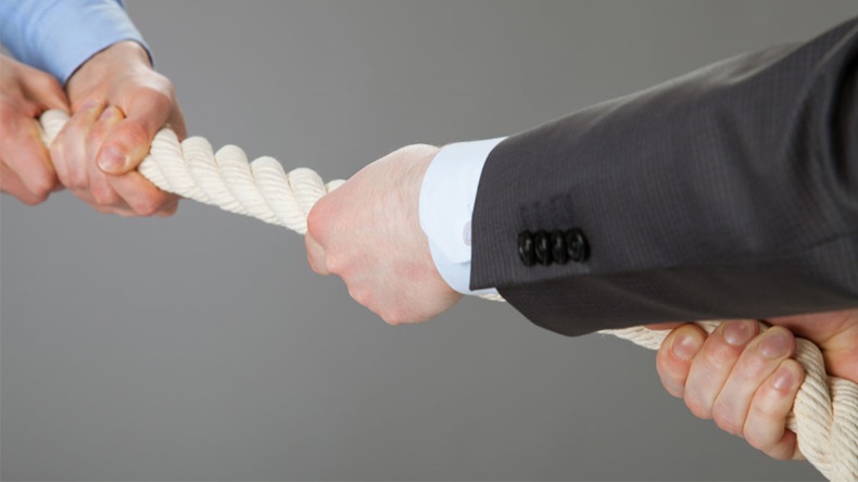 Two businessmen pulling a rope, closeup shot tug of war 